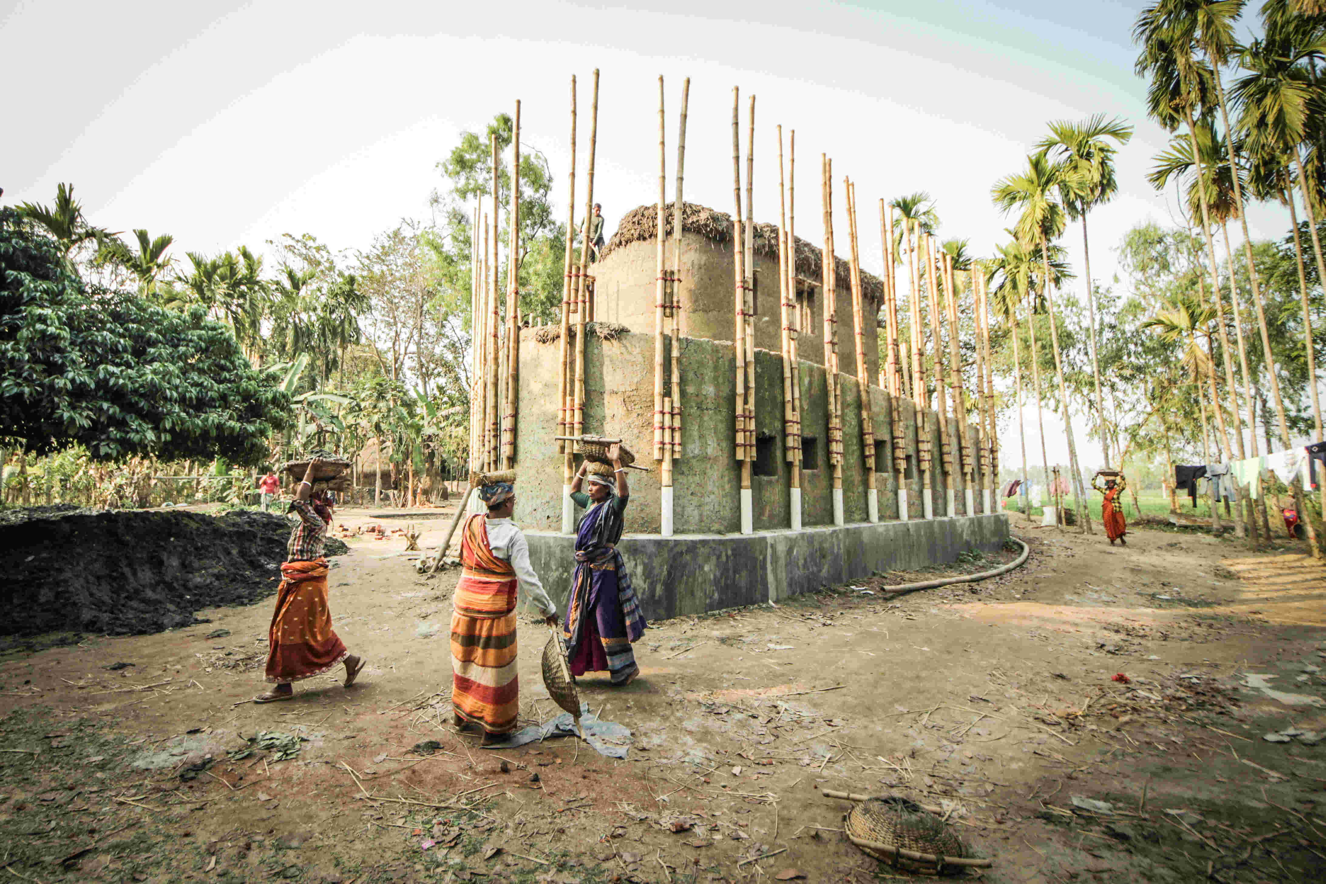 the Anandaloy Building, Rudrapur Bangladesh, shown here under construction and is made out of wood, ceramics, and bamboo. 