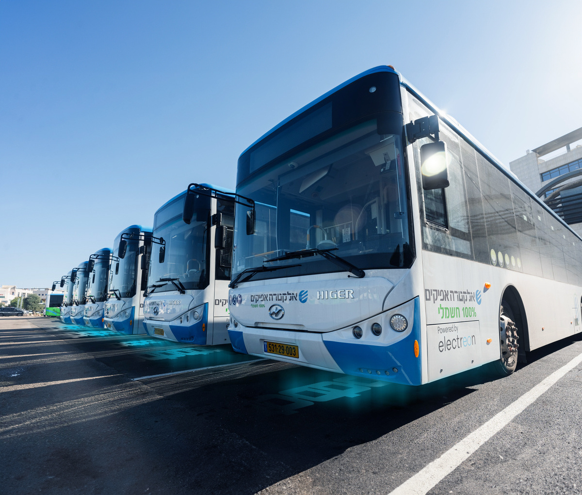 A row of electric busses at Electreon's first wireless charging bus terminal. 