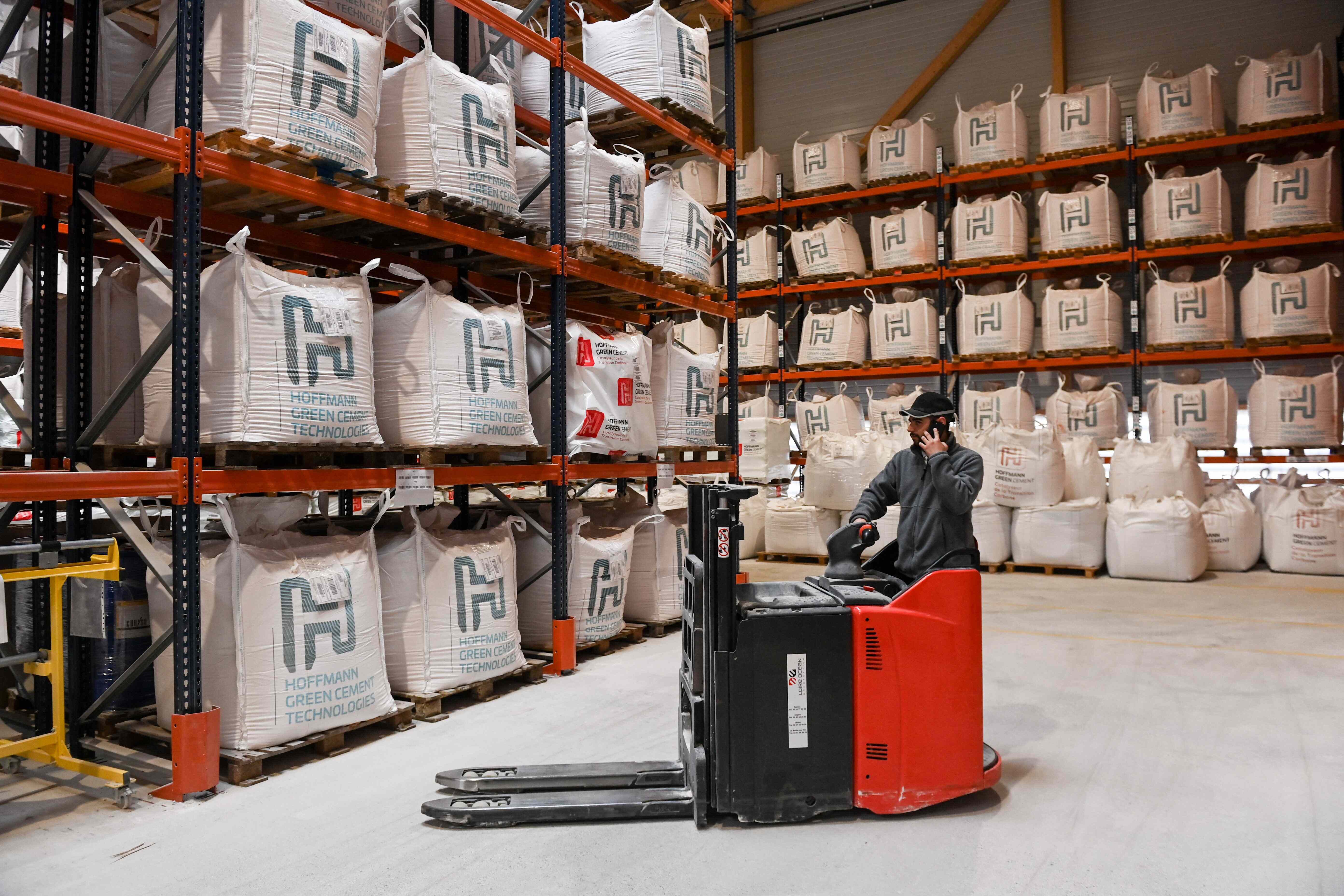 A Hoffmann Green Cement Technologies worker moves bags of cement with a forklift, in a storage room in the production site, in Bournezeau, western France.