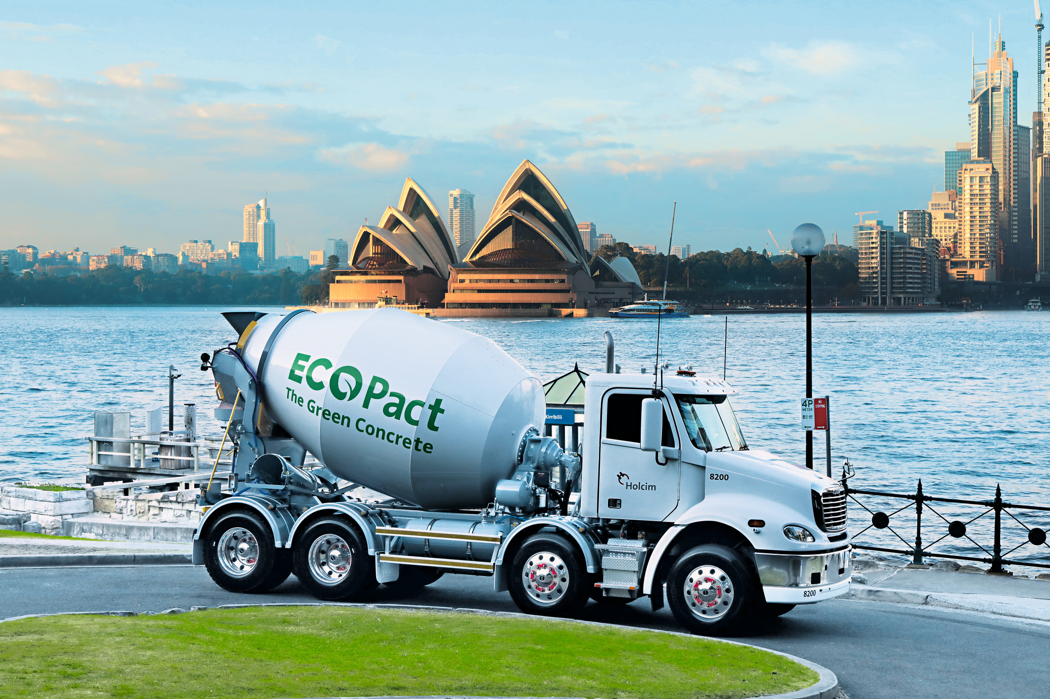 A concrete truck labeled with "ECOPact, The Green Concrete," with the Syndey Opera House and harbor in the background. 